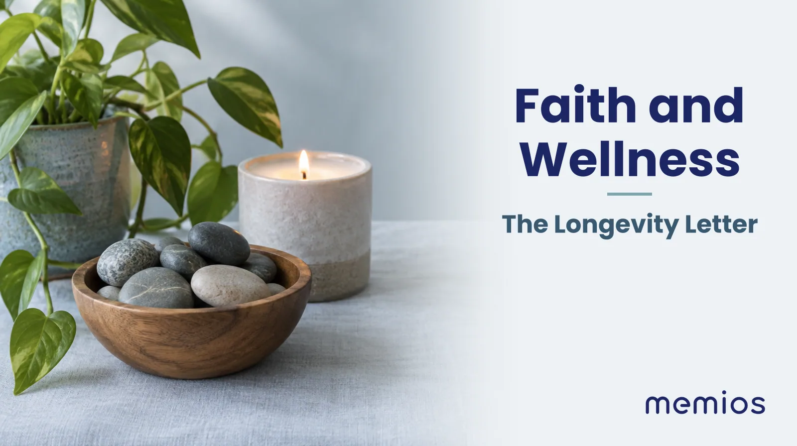 Photograph for Faith and Wellness: a small wooden bowl of smooth stones, a lit candle and a green plant on the linen.